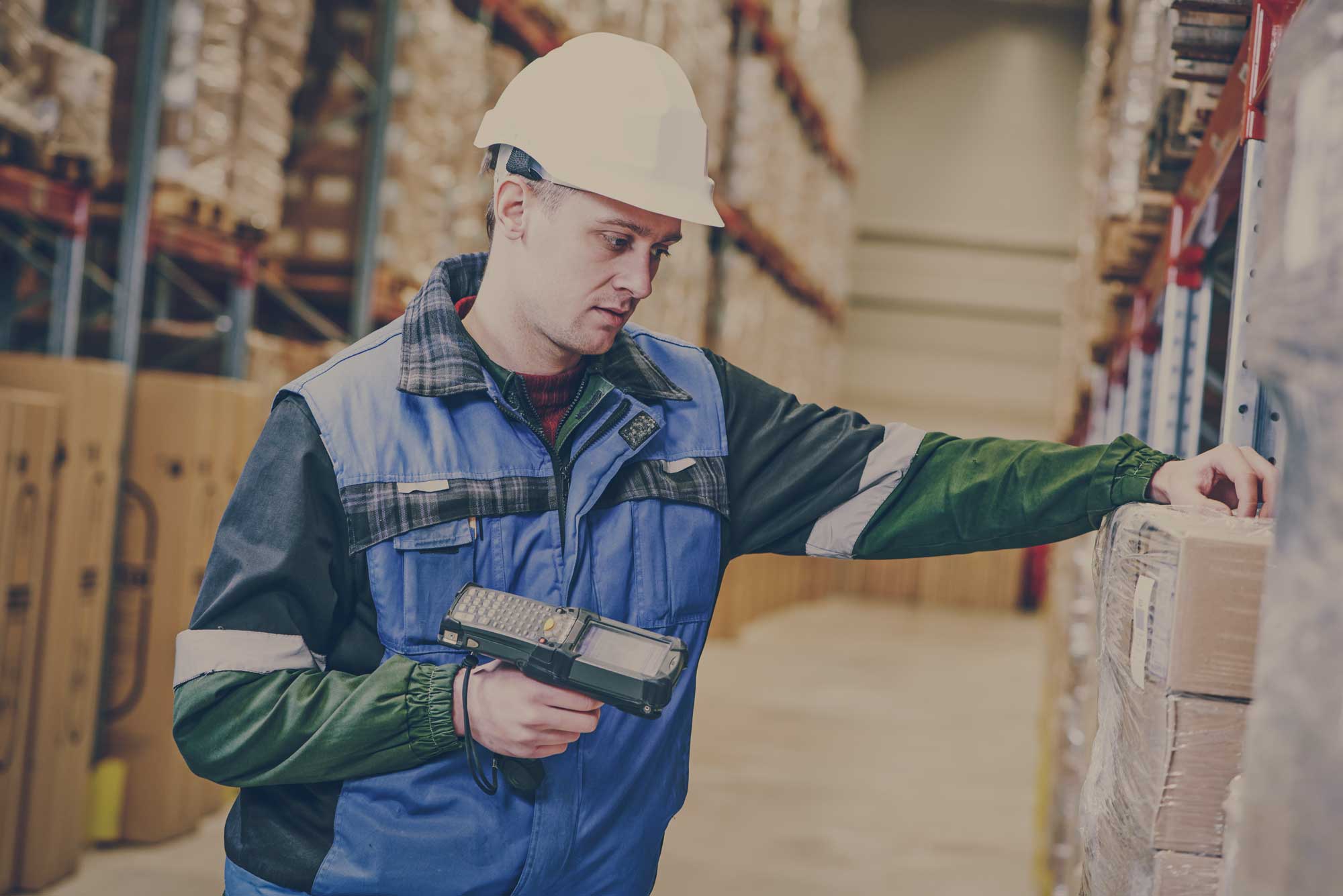 Warehouse worker scanning product on shelf using ERP system