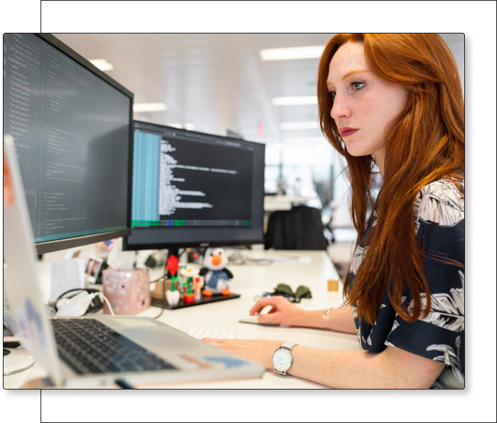 Woman working on multiple computers